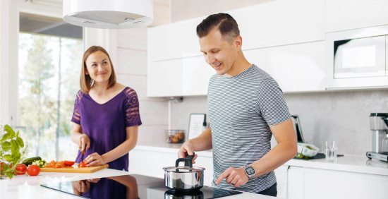 Mies ja nainen kokkailevat keittiössä. Kuvituskuva.