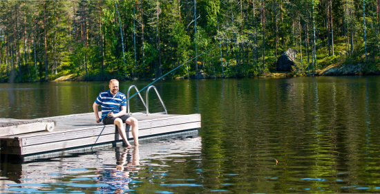 Mies istuu laiturilla ja onkii. Kuvituskuva.